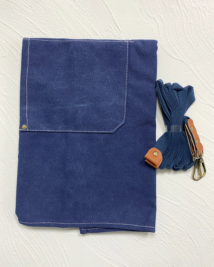 Blue fabric with a strap and keychain on a white textured background