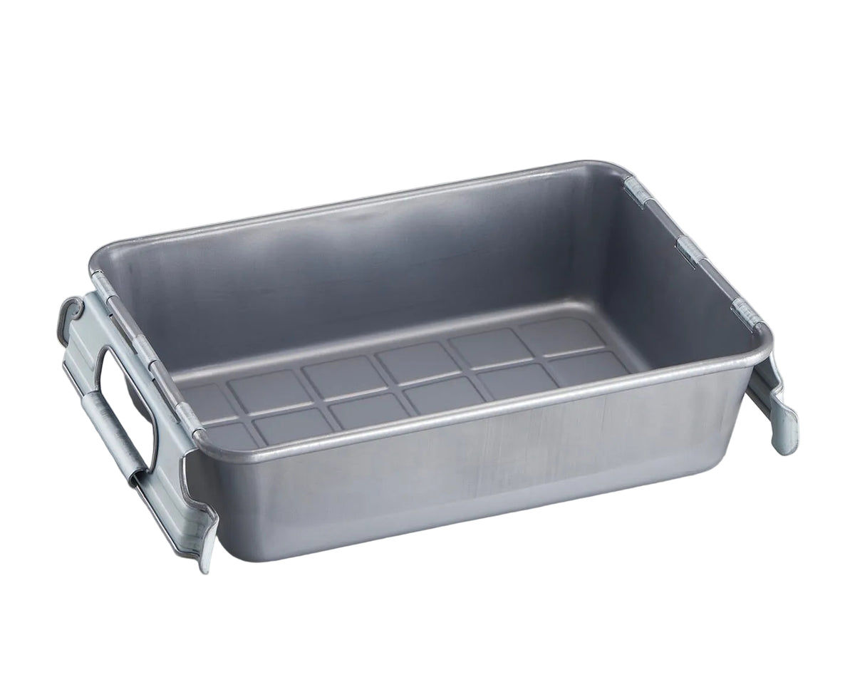 A rectangular stainless steel baking pan with integrated side handles and a textured bottom grid, photographed on a neutral light gray background.